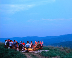 Photograph of some a group of people sitting in a circle outside at a Whole Thinking Retreat